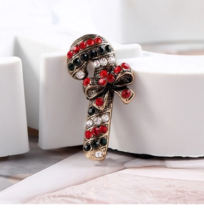 Detail of candy cane brooch with red and clear rhinestones on vintage gold base