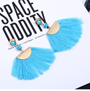 Detail of bohemian fan-shaped earrings featuring blue silk tassels and turquoise beads
