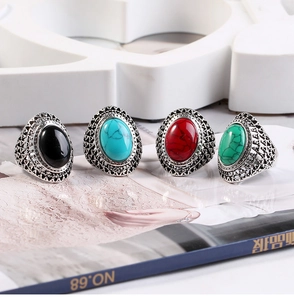 Close-up of retro silver rings with oval turquoise stones and hollow floral patterns