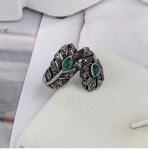 Detalle de anillo de pluma retro con piedras verdes y detalles de marcasita vintage