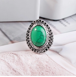 Detailed view of vintage silver ring with large oval turquoise stone and hollow carvings