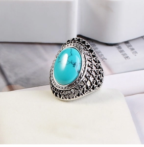 Detailed close-up of retro silver ring with oval turquoise stone and filigree engraving