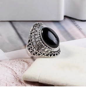 Macro shot of vintage silver ring featuring oval black stone and intricate filigree details