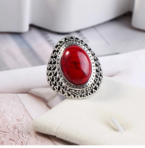 Macro view of vintage silver ring featuring ornate hollow patterns and oval red stone