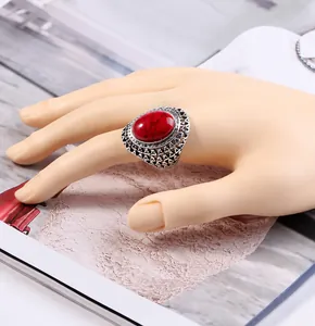 Macro detail of retro bohemian silver ring with oval red turquoise stone and carved patterns