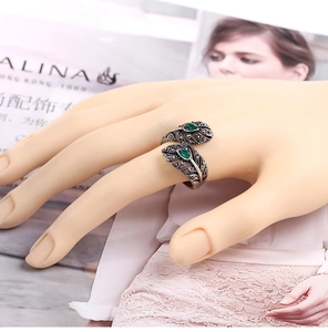Detalle macro de un anillo vintage con piedras verdes de gota y plumas de marcasita