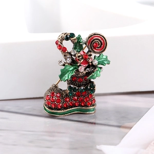 Dettaglio macro della spilla a stivale di Natale con strass, bastoncini di zucchero