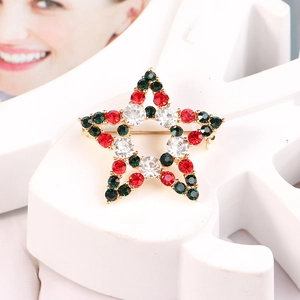 Detail of a Christmas star brooch with red, white, and green rhinestones in gold setting