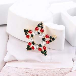 Macro detail of star brooch with red, green and clear rhinestones on gold base