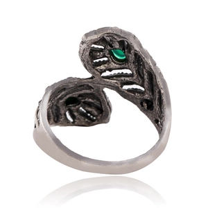 Detalle de anillo de pluma vintage con piedras verdes de gota y estilo bohemio
