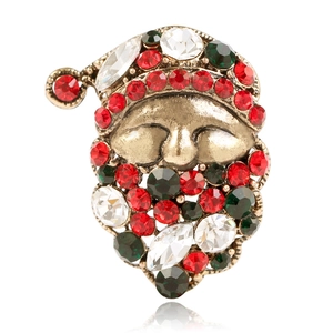 Detailed close-up of Santa Claus brooch with colorful rhinestones on antique gold base