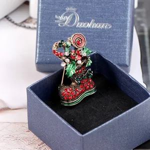 Dettaglio della spilla a stivale di Natale con strass colorati e bastoncini di zucchero