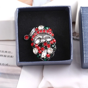 Macro shot of Santa Claus brooch with red and green rhinestones in a gift box