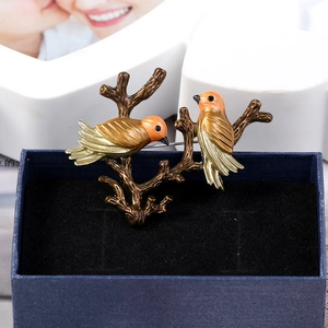 Detail of vintage bird brooch with colorful enamel on a dark jewelry box