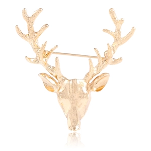 Detailed view of golden alloy stag head brooch with polished antlers and rear clasp