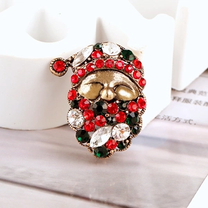 Macro shot of Santa Claus brooch featuring festive red, green, and white rhinestones
