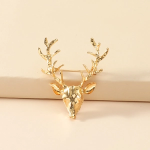 Polished golden elk head brooch with hollow antlers on minimalist beige background