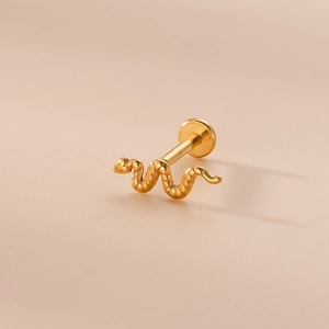 Dettaglio di un piccolo piercing a serpente dorato lucido con retro piatto su beige