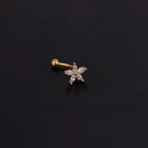 Détail macro d'un piercing en acier inoxydable avec fleurs dorées en zircons