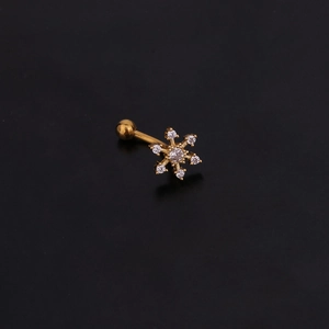 Vue macro du piercing barbell flocon doré serti de zircons brillants et fermoir à boule
