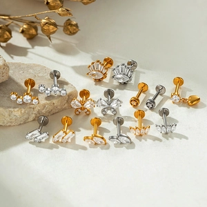 Zirkonia vlinder en geometrische labret studs in goud en zilver op natuursteen