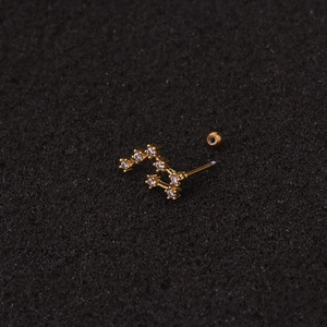Detail of gold zodiac ear stud with clear zircon and screw back ball closure