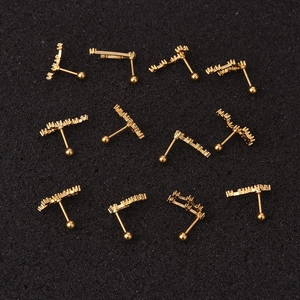Detailed view of eleven golden barbell stud earrings with paved clear zircon stones