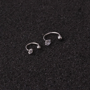 Macro detail of stainless steel horseshoe piercings with marquise cut cubic zirconia studs