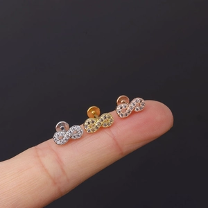 Macro detail of three infinity studs in silver, gold, and rose gold with pavé zircons