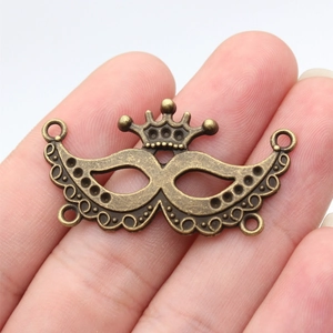 Vintage bronze alloy crown mask pendant with multiple connector rings for jewelry making