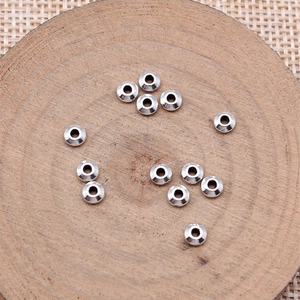 Perles d'abaque argentées accessoires bijoux DIY disposées sur un support en bois