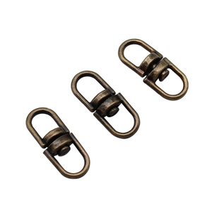 Three 16mm antique bronze swivel connectors for bags and keychains on white background