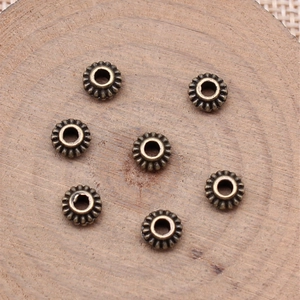 Vintage bronze gear-shaped spacer beads for DIY jewelry with floral metal detail