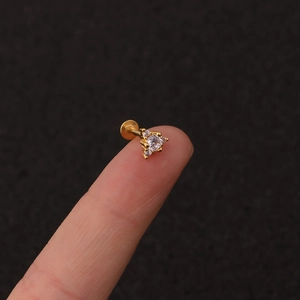 Detailed macro shot of a golden triangle zircon labret stud on a dark background
