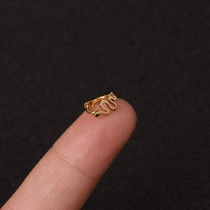 Λήψη macro από μικρό χρυσό σκουλαρίκι ear cuff στην άκρη του δακτύλου για κλίμακα