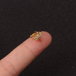 Λήψη macro από μικρό χρυσό κρίκο με αστέρι και ζιργκόν στην άκρη του δακτύλου
