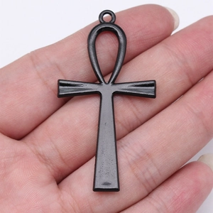 Gothic black metal Ankh cross pendant for DIY jewelry, shown held in hand for scale