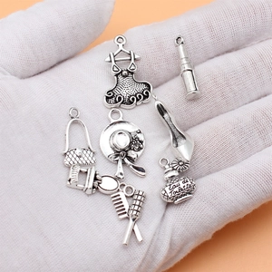 Set of 8 vintage silver alloy pendants including perfume, lipstick, and fashion charms