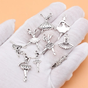 Set of 9 antique silver ballet dancer charms made of alloy metal on a palm display