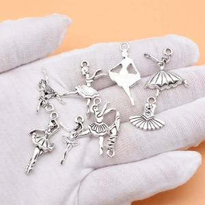 Set of 9 antique silver ballet dancer pendants for DIY jewelry making shown on hand