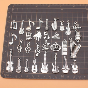Set di 30 ciondoli strumenti musicali in argento antico su tappetino graduato