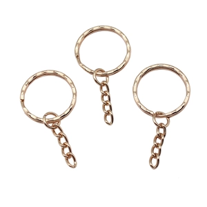 Close-up of three rose gold hammered texture keyrings with 4-link chains on white background