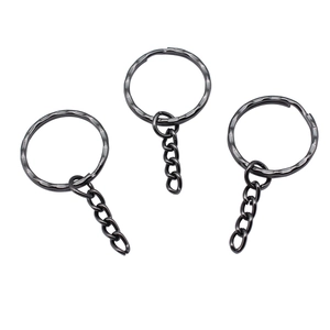 Close-up of gunmetal black textured key rings with four-link chains on white background