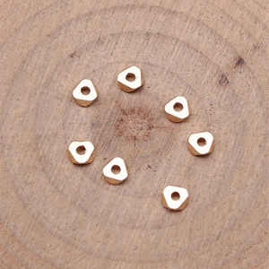 Rose gold vintage zinc alloy geometric spacer beads with holes on a wooden background