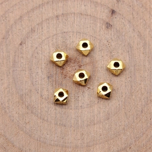 Goldene geometrische Abstandsperlen für DIY Schmuckherstellung auf Holzgrund