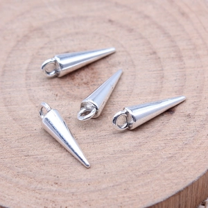 Set of four silver cone pendants for DIY jewelry making on a rustic wood background