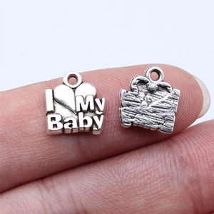 Pendentif DIY argenté avec gravure I Love My Baby présenté sur le bout du doigt