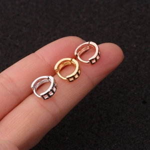 Detailed macro view of mini heart-shaped gold, silver, and rose gold hoop earrings