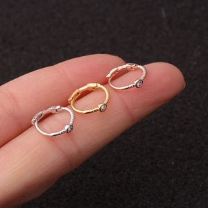 Close-up of mini twisted rope earrings with round cubic zirconia in silver, gold, rose gold