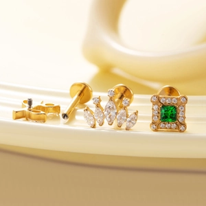 Set de joyas para piercing de titanio con corona dorada y pendientes de piedra verde